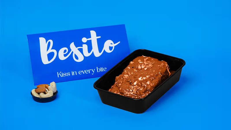 Nut-crusted chocolate milk cake next to the Besito card
